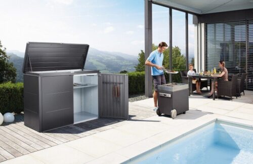 Das Biohort Highboard steht auf einer grossen Terrace vor einem pool. Neben dem Highboard steht ein Mann an einem Grill und eine Familie sitzt an einem Tisch.