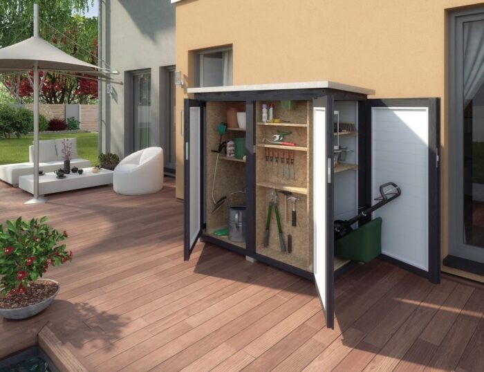 a garden cabinet standing on a terrace with a dark floor. The doors are opened and the shed is filled with various garden tools.